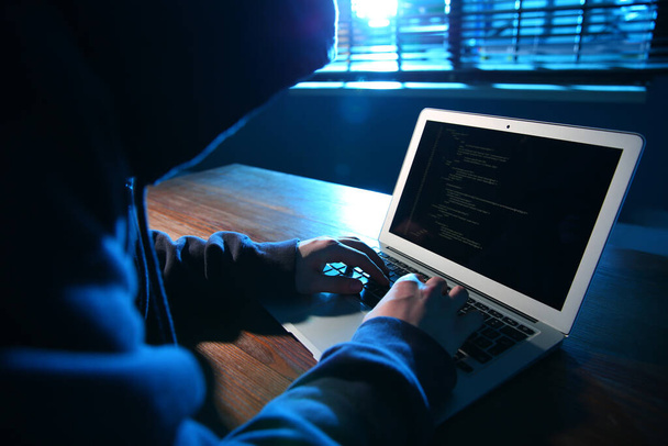 Hacker with laptop in dark room. Cyber crime - Fotoğraf, Görsel