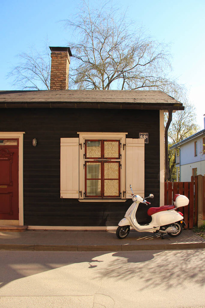 Motorscooter geparkeerd voor het vintage huis. Perfecte kleuraanpassing in het dagelijks leven. - Foto, afbeelding