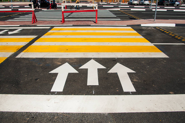 Yaya geçidi işaretleri, gri asfalt kaldırım üzerinde beyaz ve sarı dikdörtgenler. - Fotoğraf, Görsel