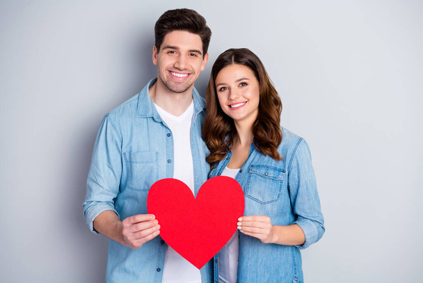Photo attractive charming lady handsome guy demonstrating per paper heart figure big postcard symbolizing love wear casual denim shirts outfit isolated grey color background - Foto, Imagem