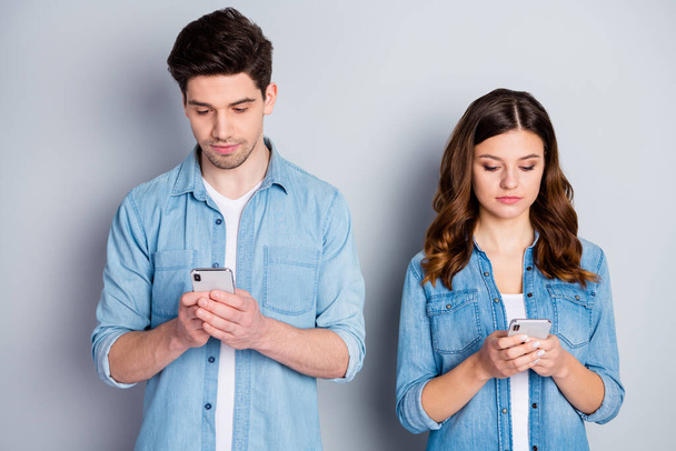 Photo pretty lady handsome guy careless couple look telephone screen ignoring each other addicted users wear casual denim shirts outfit isolated grey color background - Foto, Bild