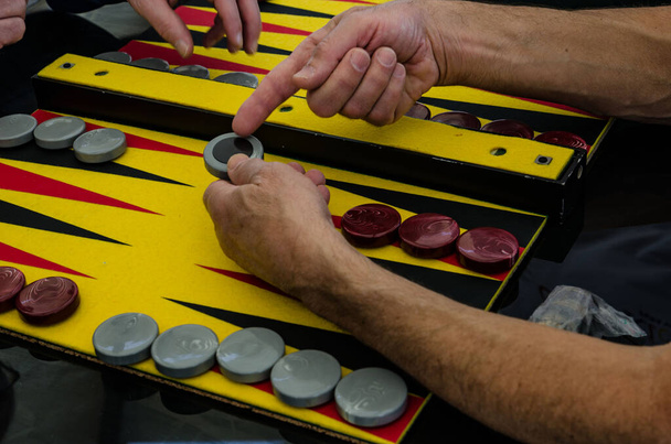 backgammon spel, chips, dobbelstenen voor het spel, spelers aan de speeltafel - Foto, afbeelding