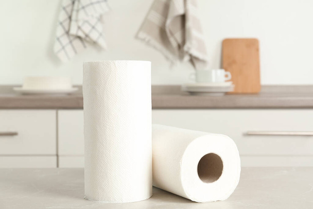Rolls of paper towels on light grey marble table in kitchen - Photo, image