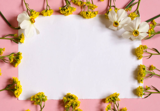 Frame of flowers. White piece of paper sheet on a pink background. Place for your text. Floral background. - Φωτογραφία, εικόνα
