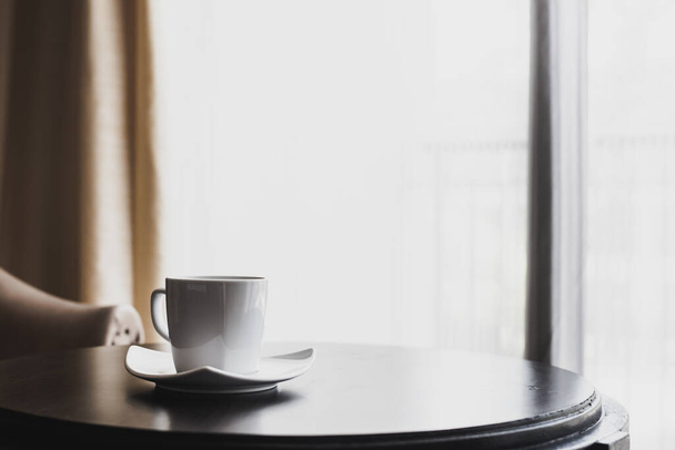 Чашка черного кофе, газета и ручка у окна утром
 - Фото, изображение
