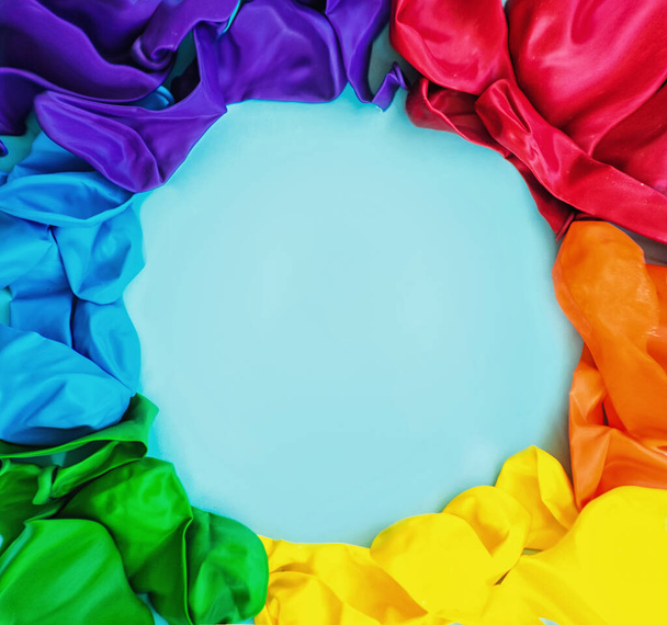 Bandera LGBT pintada aislada sobre un fondo azul. Símbolo LGBT multicolor de bolas de colores. Copiar espacio, banner
 - Foto, imagen