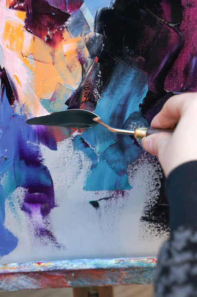 Pintura al óleo sobre lienzo está escrito por paleta cuchillo. Primer plano de una pintura al óleo y cuchillo de paleta sobre lienzo
.  - Foto, Imagen