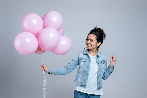 girl in denim holding pastel pink air balloons - Photo, image