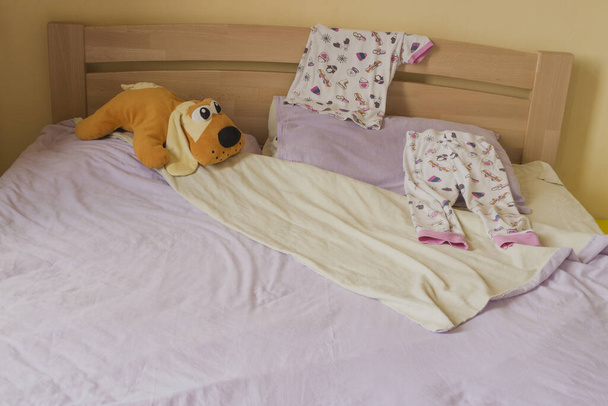 Πιτζάμες και παιδικά παιχνίδια στο κρεβάτι - Φωτογραφία, εικόνα