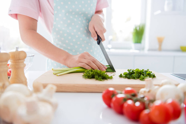 Cropped close-up view of her she hands girl making meal cutting green vitamin weight loss salad on wooden board cutter table desk in modern white light interior style kitchen indoors - Foto, Bild