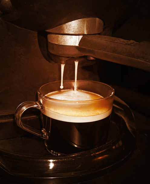 Close-up of espresso pouring from coffee machine. Professional coffee brewing                                - Фото, изображение