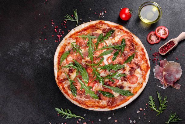 Świeża pizza pieczona w piekarniku z rukolą, salami, pomidorami wiśniowymi i mozzarellą. Kuchnia włoska - Zdjęcie, obraz