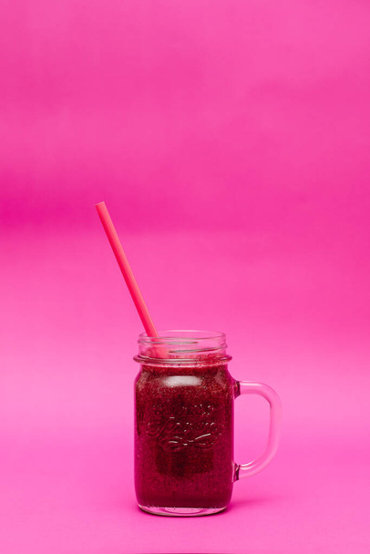 Zdrowy ciemnoczerwony koktajl w szklanym słoiku na różowym tle - Zdjęcie, obraz