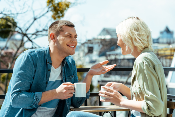 couple souriant parler et boire du thé sur la terrasse
 - Photo, image