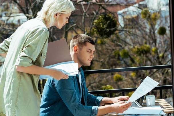 liikemiehet työskentelevät kannettavan tietokoneen ja paperit aurinkoisella terassilla
 - Valokuva, kuva