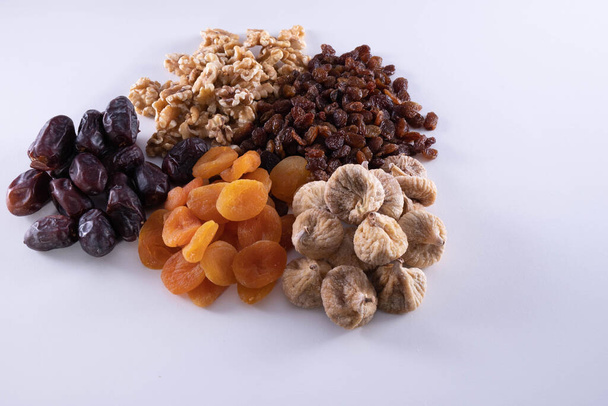 dried apricot, nuts, faygi, dates and raisins on a wooden background - Foto, afbeelding