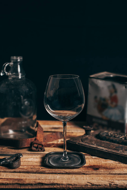 Wine glass on wood with black background. Style with vintage decoration of rusty metals and leather. - Fotografie, Obrázek