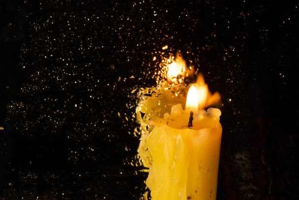 de vlam van een kerkkaars in een donkere kamer - Foto, afbeelding