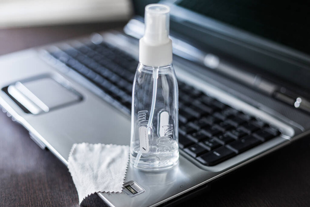 Using a medical antibacterial antiseptic gel in the workplace while working online at home at the computer. Protection at coronavirus and covid - Fotó, kép