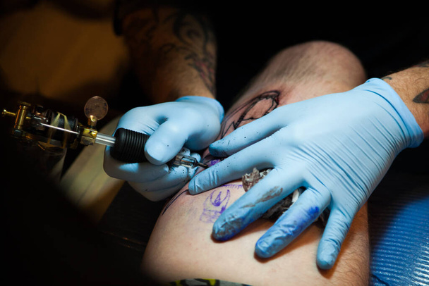 Részlet egy fiatal férfi tetovált a comb a láb - Fotó, kép
