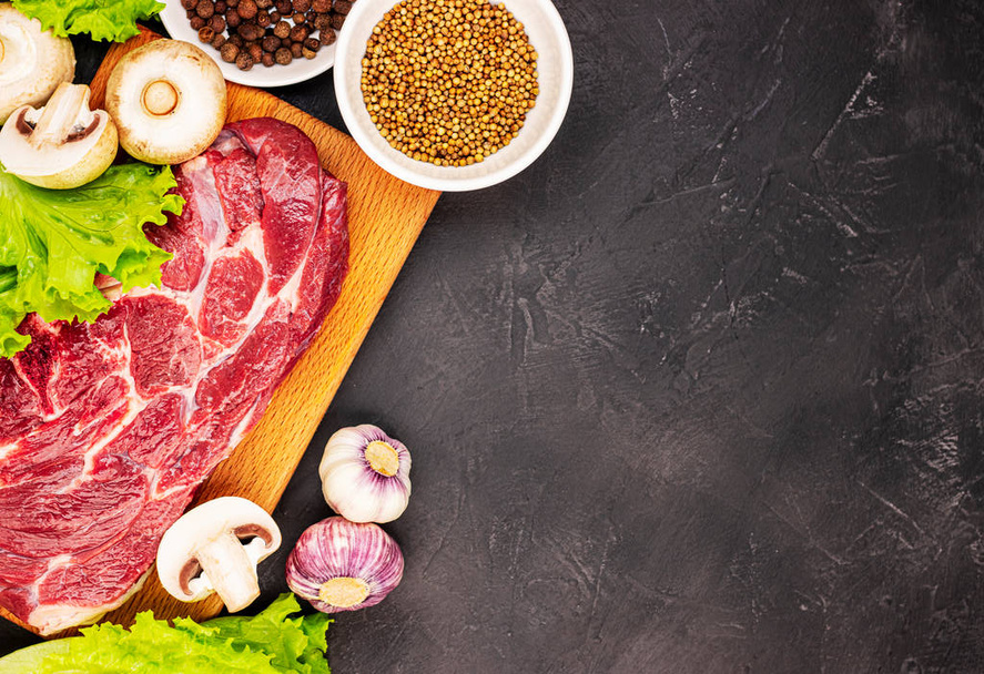 Raw fresh marble meat steak and seasonings on a dark marble background, top view. fresh greens with mushrooms, garlic and beef - Photo, image