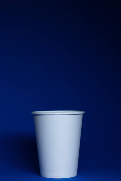 Prázdný bílý papírový kelímek na modrém pozadí - Fotografie, Obrázek