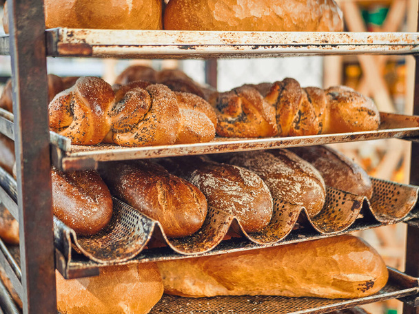 Freshly baked bread on trays in a self-catering supermarket. - Fotoğraf, Görsel
