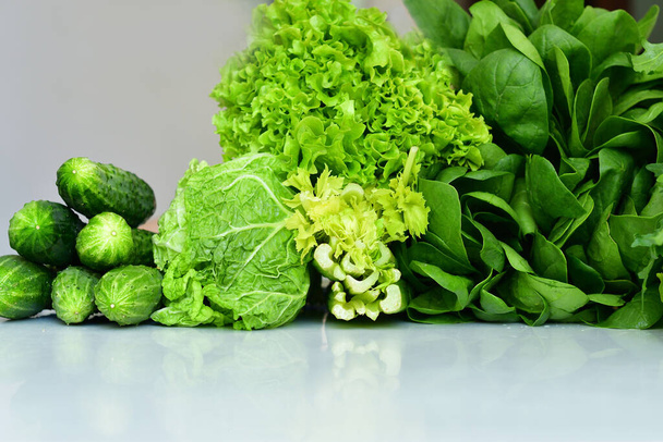 Sulu taze ıspanak, roka, marul salatası, lahana, beyaz arka planda salatalık. Taze organik çiğ yeşillik. Bahar avitaminozu. Makro detoks sıvısı için malzemeler. Seçici odak - Fotoğraf, Görsel