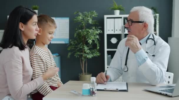 Mãe e filho conversando com o médico durante consulta no hospital infantil
 - Filmagem, Vídeo