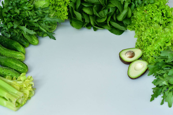 fresh spinach, arugula ,Lettuce salad, avocado on a white background.Fresh Organic Raw Greens and vegetables. .Spring avitaminosis.ingredients for detox smoothie Macro. Selective focus. Flat lay - Fotó, kép