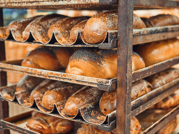Freshly baked bread on trays in a self-catering supermarket. - 写真・画像
