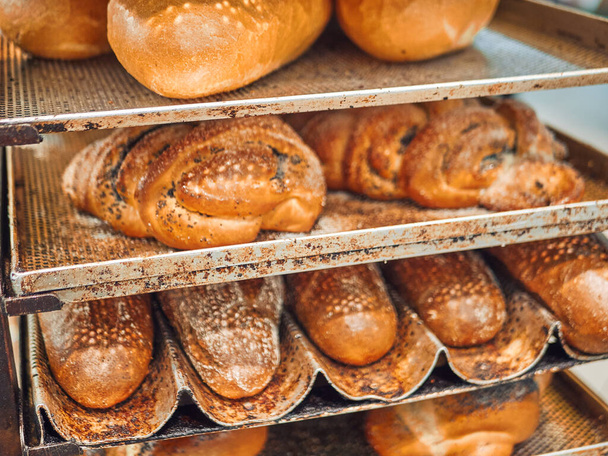 Świeżo upieczony chleb na tacach w supermarkecie samoobsługowym. - Zdjęcie, obraz