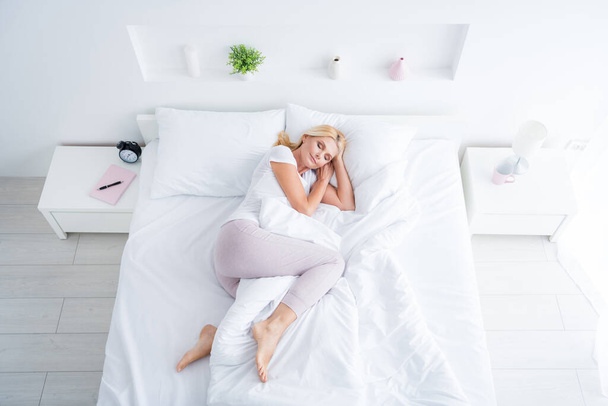 Top above high angle view of her she nice attractive healthy dreamy aged woman lying in bed sleeping in silence spending weekend in modern light white interior room flat apartment - 写真・画像