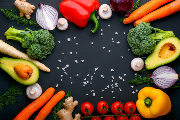 Veganistisch gezond voedsel. Groenten en fruit. Op een zwarte achtergrond. Bovenaanzicht. Kopieerruimte. - Foto, afbeelding