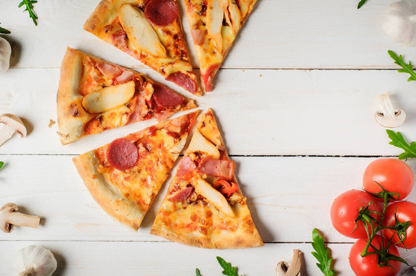 Włoska pizza z pomidorem, mięsem i serem na rustykalnym drewnianym stole. Włoska pizza na ciemnym drewnianym tle. widok z góry. - Zdjęcie, obraz