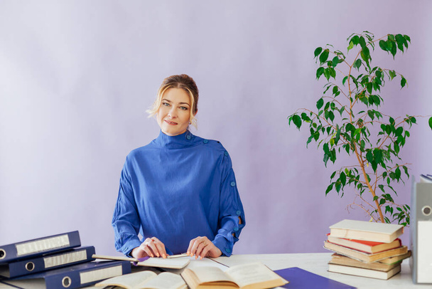 портрет ділової жінки за столом з книгами та документами на роботі в офісі
 - Фото, зображення