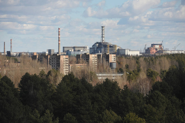 Abandoned ghost town Pripyat, view of nuclear power plant, post apocalyptic city, winter season in Chernobyl exclusion zone, Ukraine - Photo, Image