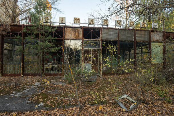 Εγκαταλελειμμένο κατάστημα στην πόλη φάντασμα Pripyat, μετα-αποκαλυπτική πόλη, φθινοπωρινή εποχή στη ζώνη αποκλεισμού του Τσερνομπίλ, Ουκρανία. Επιγραφή στα ρωσικά: "Firefly" - Φωτογραφία, εικόνα