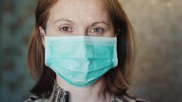Portrait of a young woman in a medical mask. The quarantine concept - Imágenes, Vídeo