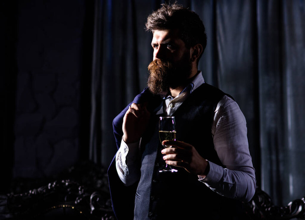 Bearded man with confident face holds champagne glass. - Photo, image
