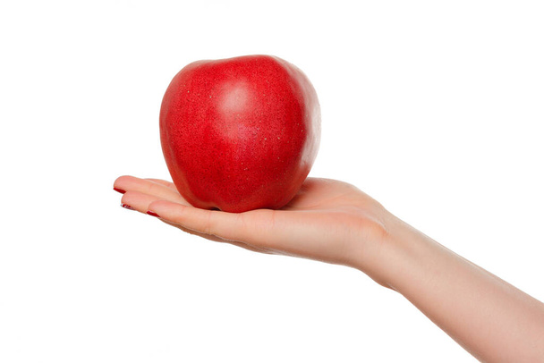 Womans hand holding red apple. Isolated on a white background. - Фото, зображення