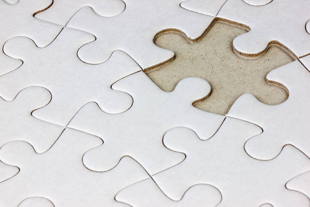 Close-up white jigsaw puzzle with a missing piece - full frame white background - Photo, Image