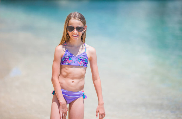 Imádnivaló kislány érezd jól magad a trópusi strandon nyaralás közben - Fotó, kép