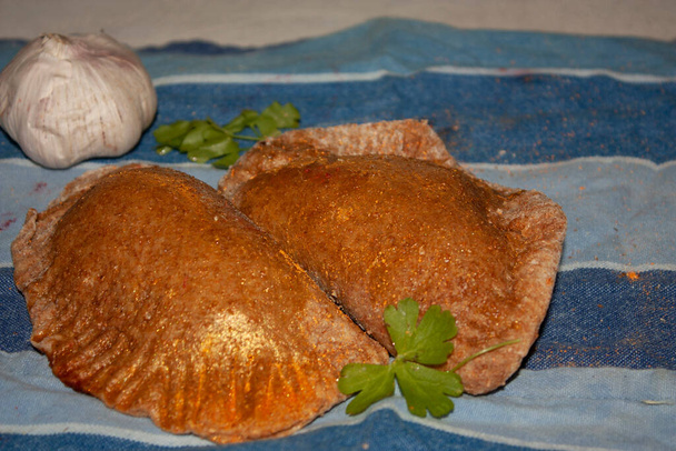 Verse gezonde volkoren gezouten pasteitjes gevuld met knoflooksmaak kip en peterselie genuanceerd met eetbaar goud - Foto, afbeelding