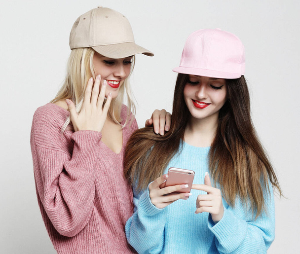 Two teenage girls friends in hipster outfit make selfie on smar - Фото, изображение