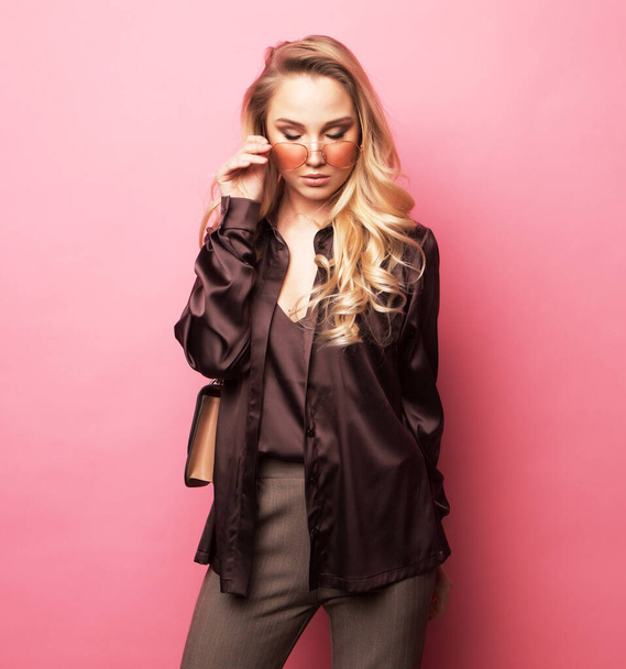 Stylish blond woman in blouse and pants, wearing sunglasses . - Foto, afbeelding