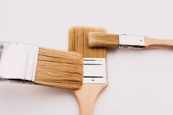 Simple background with new wooden paintbrushes isolated on white studio background. - Foto, afbeelding