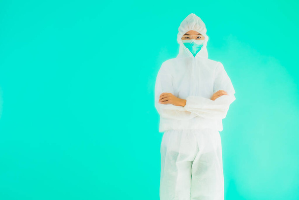 Portret mooie jonge aziatische arts vrouw dragen ppe of persoonlijke beschermingsmiddelen voor bescherming tegen coronavirus of covid19 op blauw geïsoleerde achtergrond - Foto, afbeelding