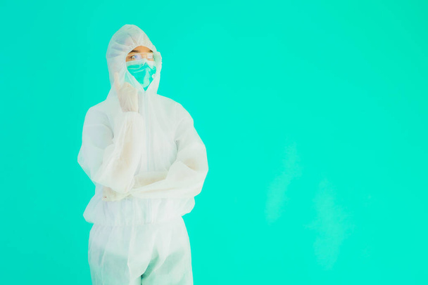 Portret piękna młoda azjatycka lekarz kobieta nosić ppe lub osobisty sprzęt ochronny dla ochrony przed koronawirusem lub covid19 na niebieskim odizolowanym tle - Zdjęcie, obraz