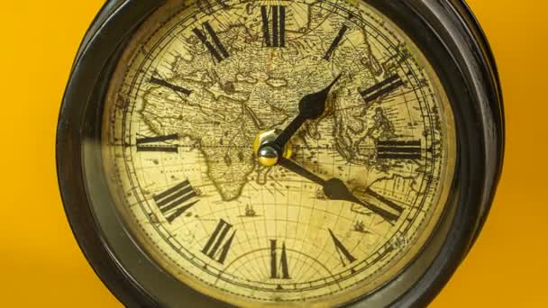 Starožitný budík hodiny s světovou mapou běh čas lapse 4k na žlutém pozadí studio - Záběry, video